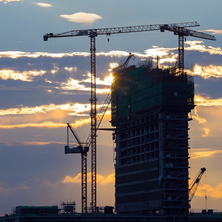 Construction crane and high-rise in silhouette representing AFL-CIO Housing Investment Trust.