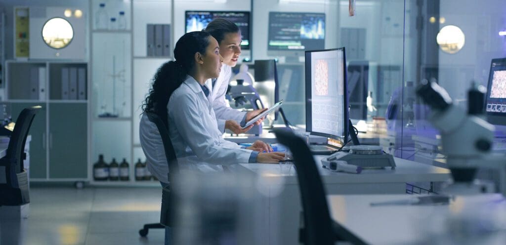 Women review brain scan images in life science lab. Women review brain scan images in life science lab.
