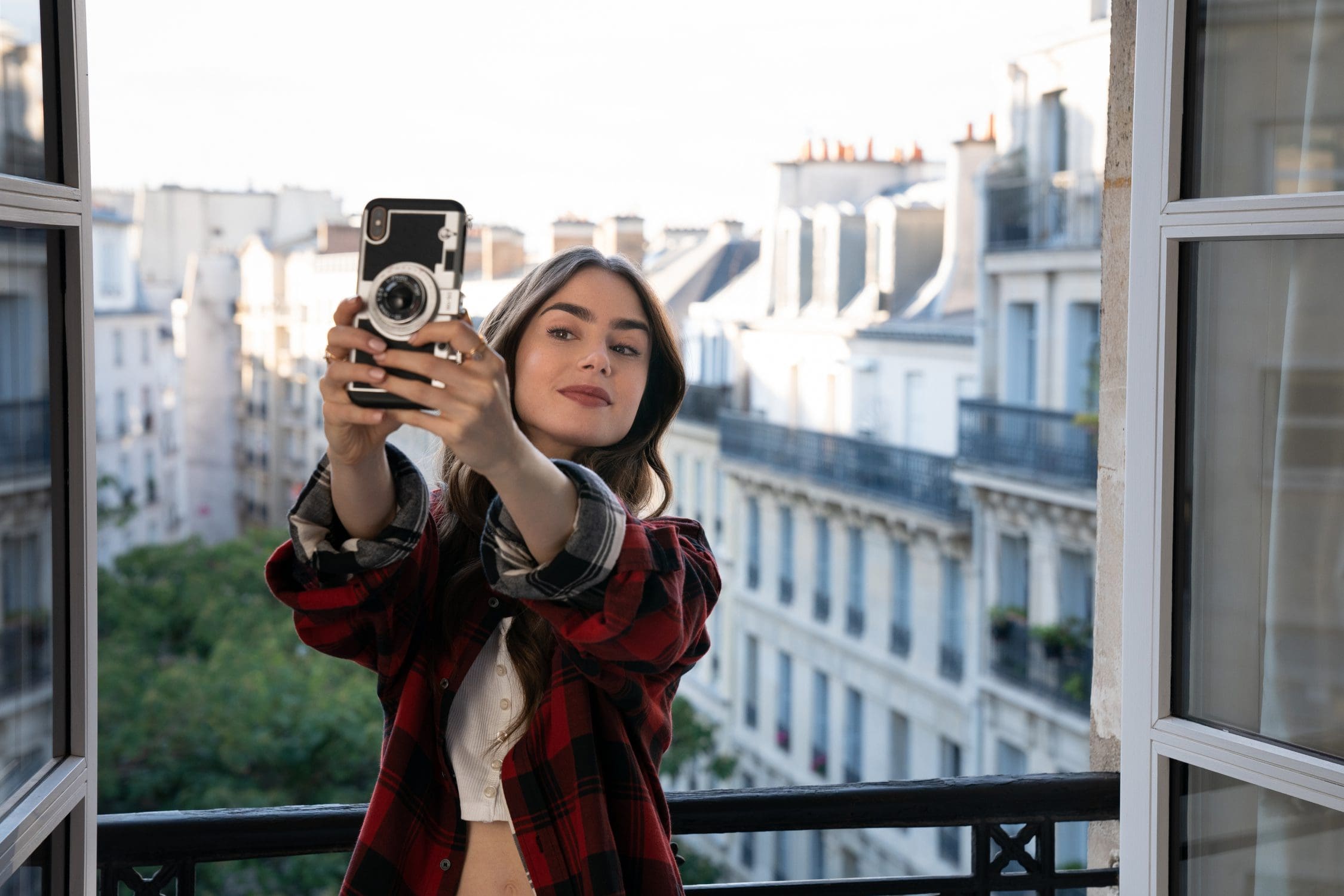 Woman on balcony poses for social media selfie.