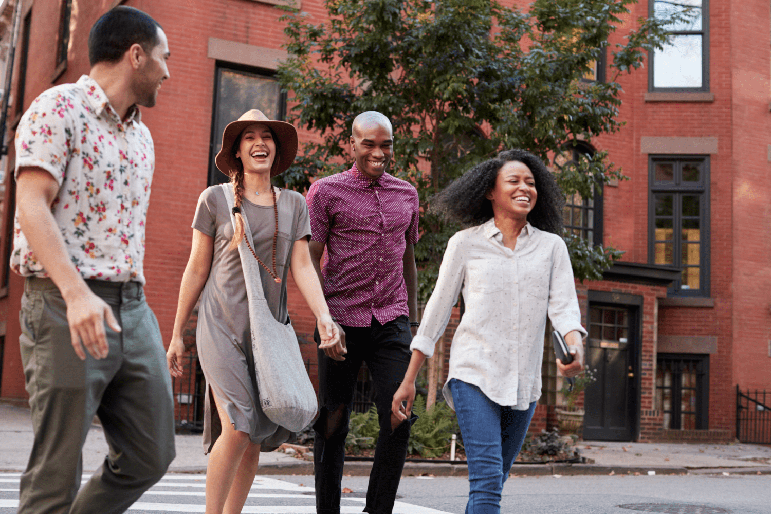 Two couples cross a city street in an Airbnb promotional image.